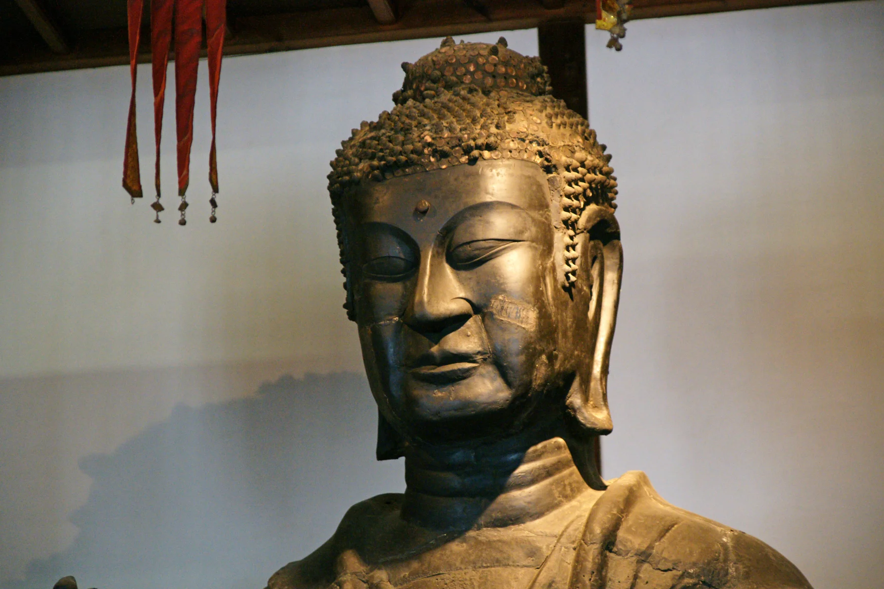 飛鳥寺釋迦如來的真實略斜角近拍，金色側光照亮古銅佛面，663highland 攝影